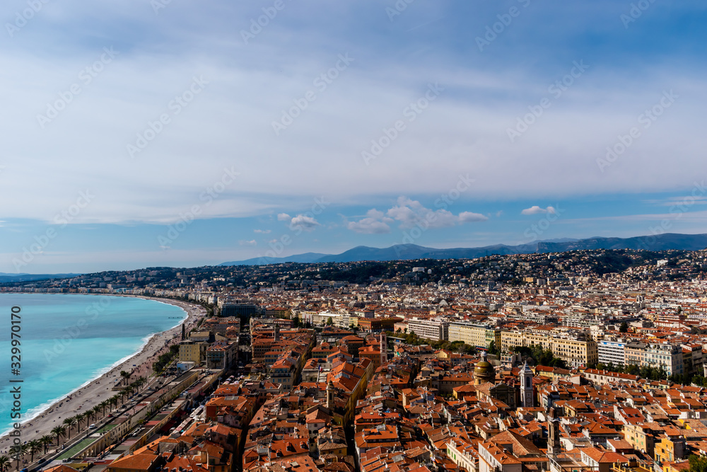 Panorama of the old town of Nice, France, the Mediterranean Sea shore and turquoise water, and the distant Alps mountains (Provence / French Riviera / Côte d'Azur)