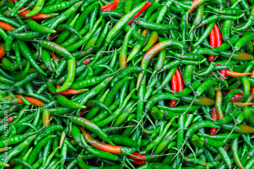 Close up image of a pile of fresh Thai green and red paprika sold in fresh market.