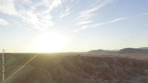 Carrizo Badlands at Anza Borrego Desert State Park at Sunrise, Pull up aerial view with intense Sun flare. photo