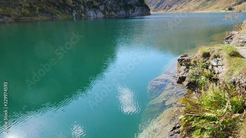 Sunny autumn alpine Tappenkarsee picturesque lake with clear transparent water, Kleinarl, Land Salzburg, Austria. Sunlight reflections blinking on water surface and lens flares available.