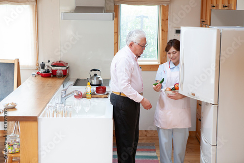 高齢男性と介護士が冷蔵庫の中を確認している photo