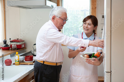高齢男性の食事の手伝いをする介護士 photo