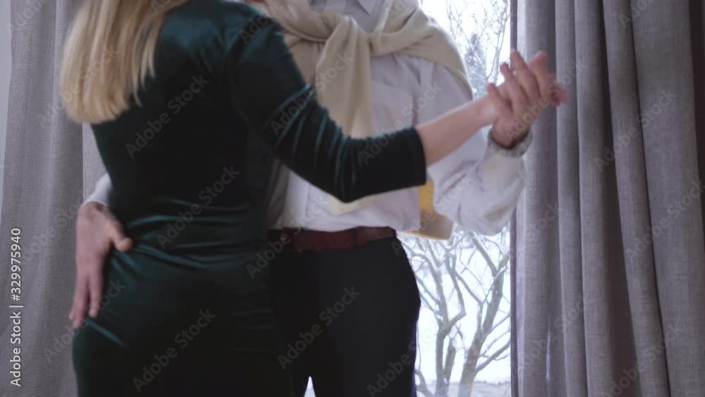 Back view of elegant young woman dancing with senior man indoors. Camera moving down as mature guy touching female body in dress. Love, romance, leisure, lifestyle. Back view of elegant young woman dancing with senior man indoors. Camera moving down as mature guy touching female body in dress. Love, romance, leisure, lifestyle.