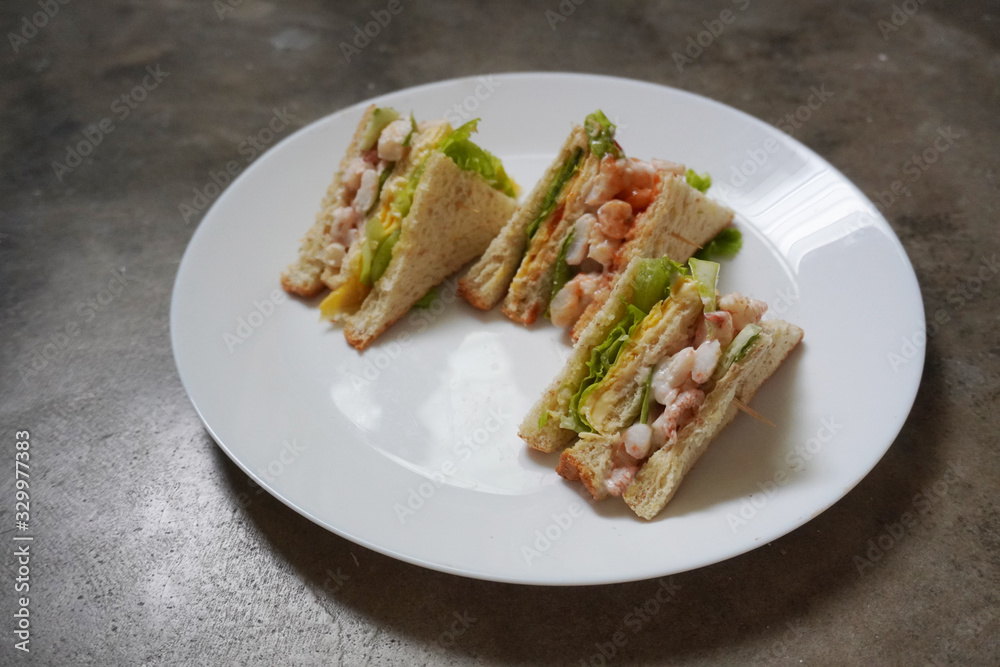 Delicious crayfish/king prawn with cheese and omelette sandwich on malted bread and mayonnaise on fresh lettuce.