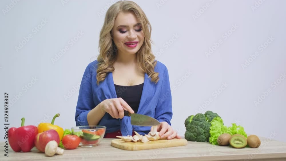 Concept of healthy eating, the woman cuts fresh vegetables for salad Concept of healthy eating, the woman cuts fresh vegetables for salad