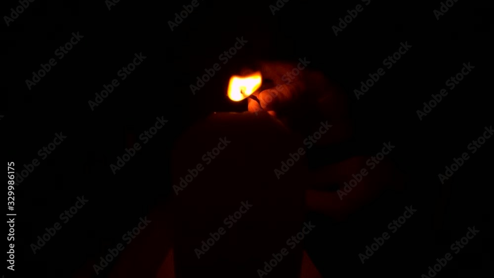 Lighting a candle with a match in the dark. Lighting a candle with a match in the dark.