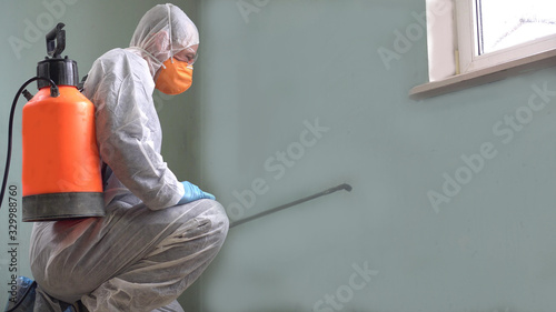 Coronavirus pandemic - Cleaning and Disinfection. Professional teams for disinfection efforts. Infection prevention and control of epidemic. Protective suit and mask photo