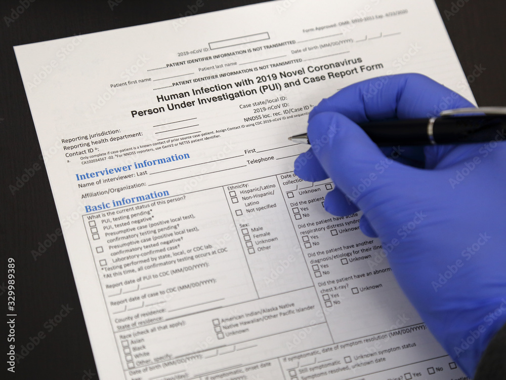 Gloved Hand Filling Out a Coronavirus Report Form