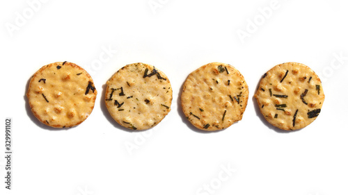 Four round seaweed rice crackers in a row on a white background
