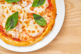italian pizza on the wooden background, top view