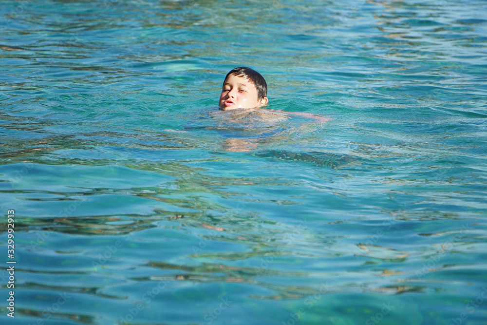 мальчик плывет в бассейне