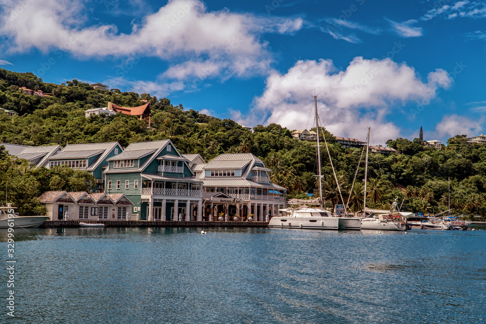 Marigot Bay in St. Lucia. Boats moored in the harbor. Caribbean island with many palm trees and sailing boats. Marigot Bay in St. Lucia. Boats moored in the harbor. Caribbean island with many palm trees and sailing boats.
