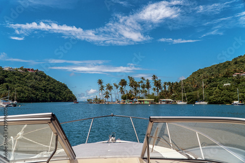 Marigot Bay in St. Lucia. Boats moored in the harbor. Caribbean island with many palm trees and sailing boats. Yacht view. Luxury cruise around islands.