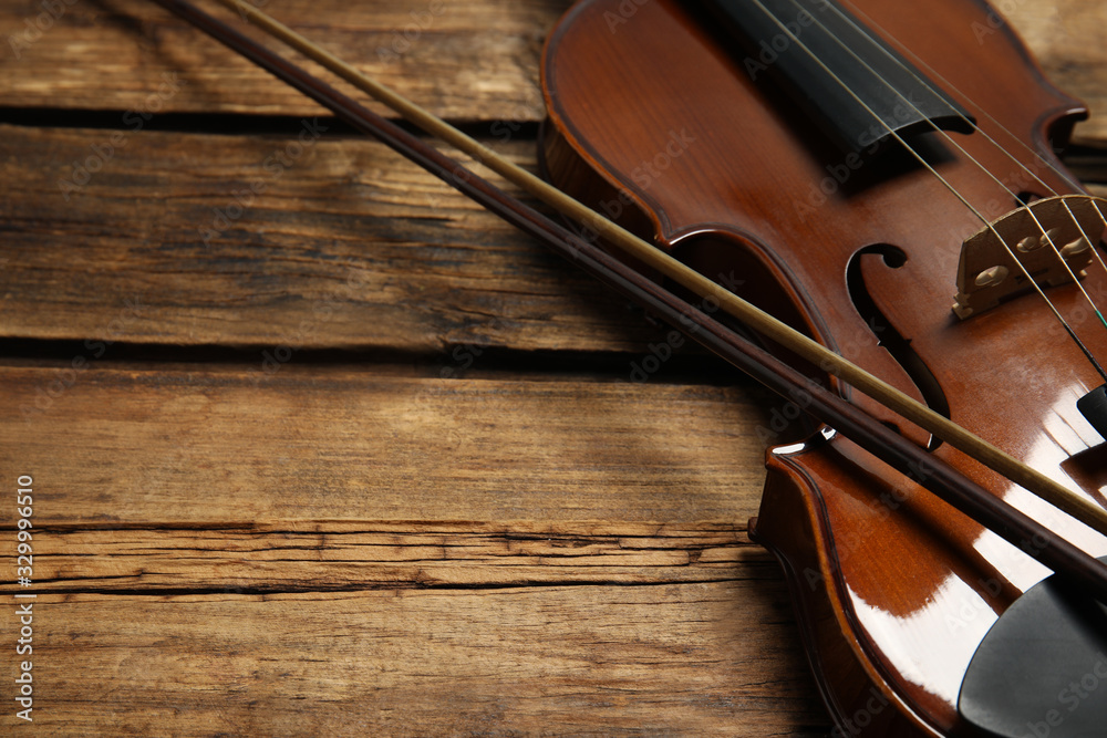 Classic violin and bow on wooden background, closeup. Space for text Classic violin and bow on wooden background, closeup. Space for text