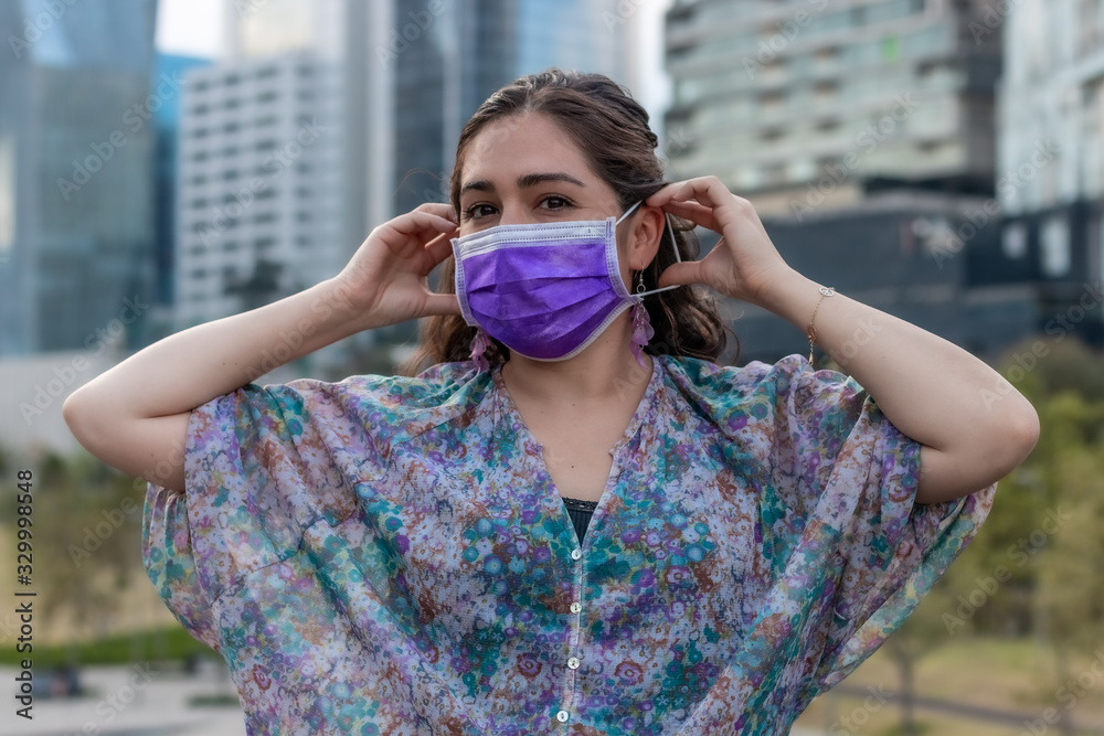 Young woman putting on a mask for respiratory protection. Coronavirus, COVID-19 Young woman putting on a mask for respiratory protection. Coronavirus, COVID-19