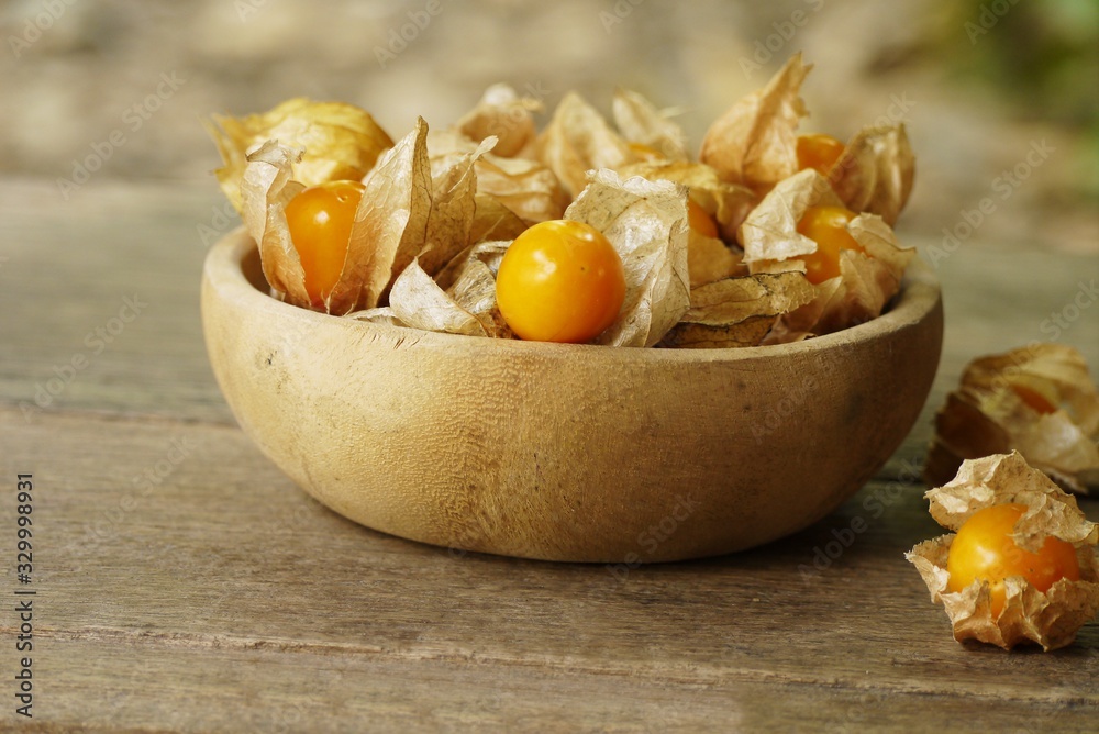 Cape Gooseberry on wooden bowl use for backgroud or wallpaper , selective focus . Cape Gooseberry on wooden bowl use for backgroud or wallpaper , selective focus .