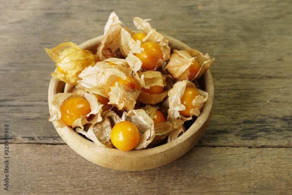Cape Gooseberry on wooden bowl use for backgroud or wallpaper , selective focus . Cape Gooseberry on wooden bowl use for backgroud or wallpaper , selective focus .