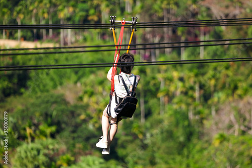 The girl descends on a bungee in the park.