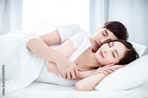 relaxed Young couple sleep together in bed