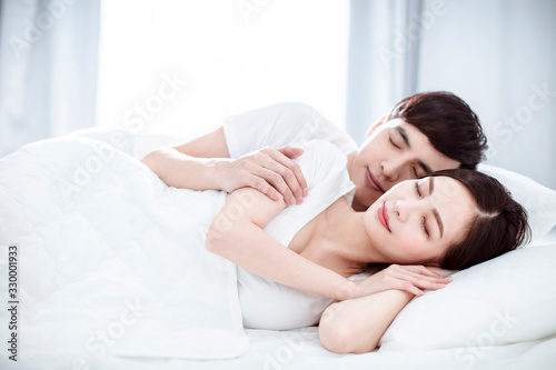 relaxed Young couple sleep together in bed
