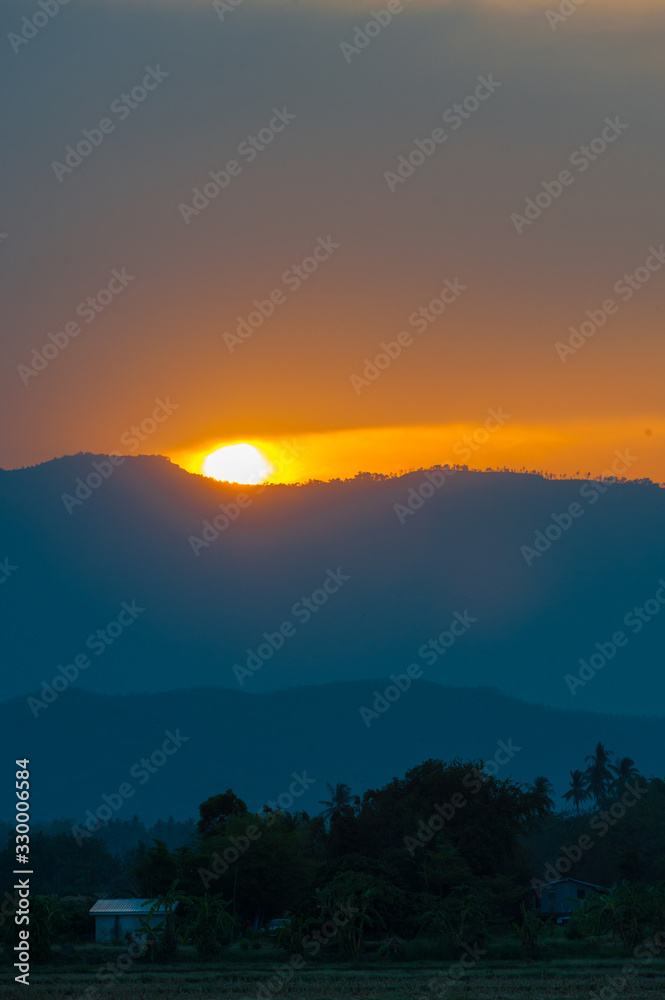 Golden light sunset behide the mountain in the evening
