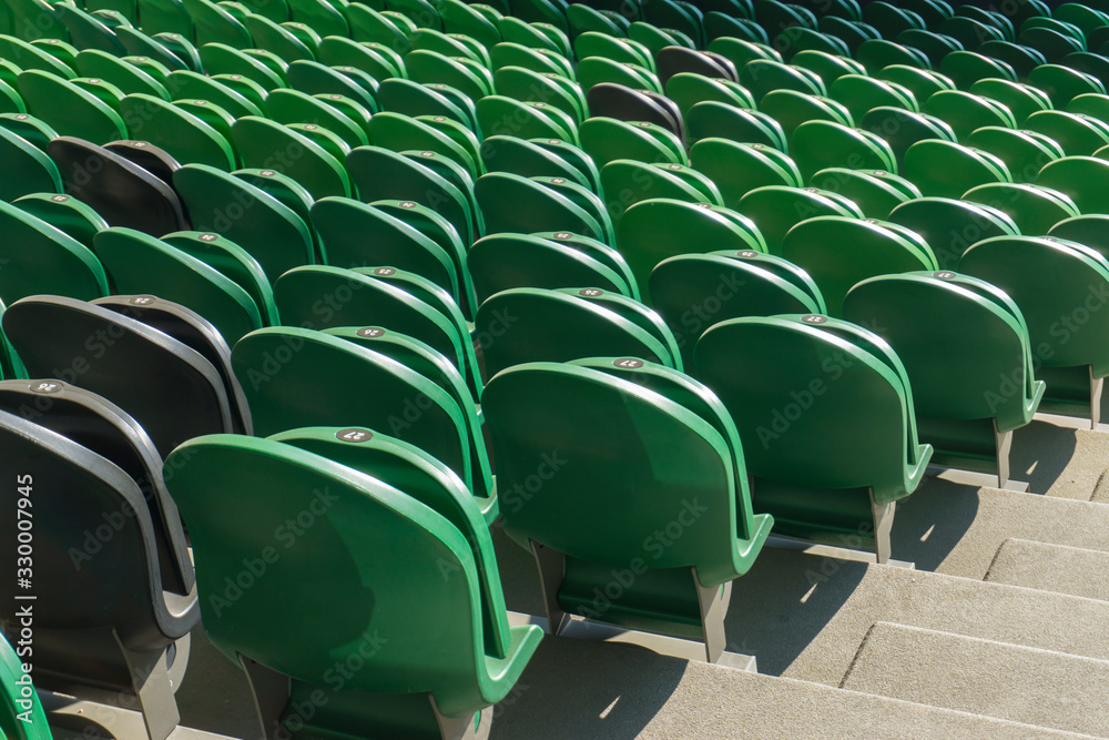 Fototapeta premium Empty plastic seats in a stadium. Matches to be played without fans.