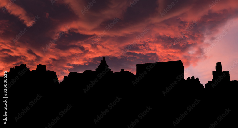 Silhouettes of houses and roofs against the sunset. City houses on the background of a colorful sunset with clouds.