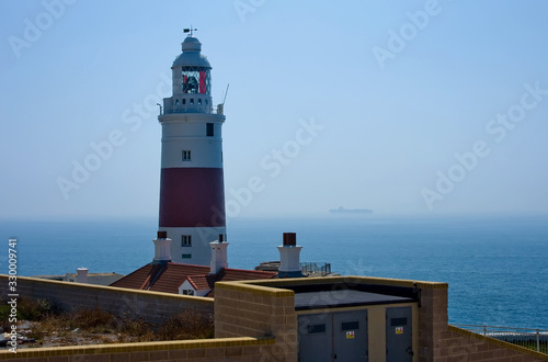 Lonely lighthouse stands against the blue sky