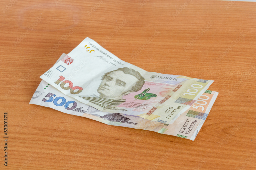 New Ukrainian hryvnia (UAH) banknotes on wooden table. New Ukrainian hryvnia (UAH) banknotes on wooden table.