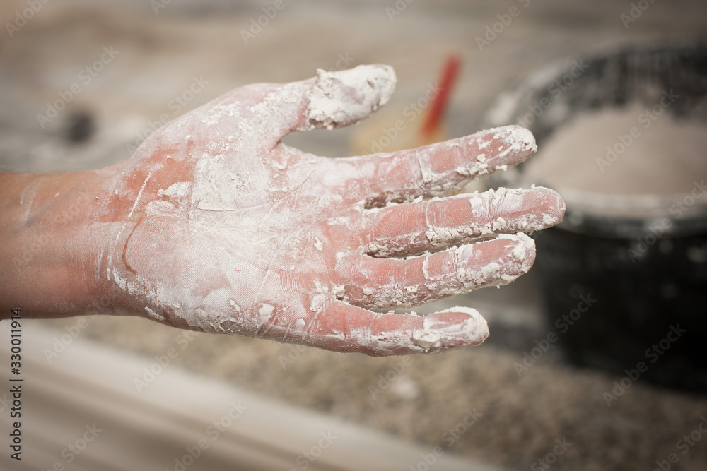 Fototapeta premium Dreckige Hand eines Stukkateurs mit trockenen Gips Resten