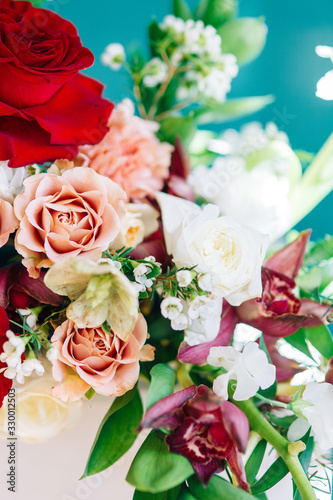 Decor of a stylish wedding ceremony. The decoration of the arch with red roses and wedding floristry. Modern trends in wedding bouquets.