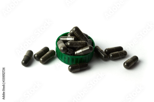 capsule of Nigella sativa ( black caraway, black cumin, black seed ), herbal capsules from habbatussauda isolated on white background. photo