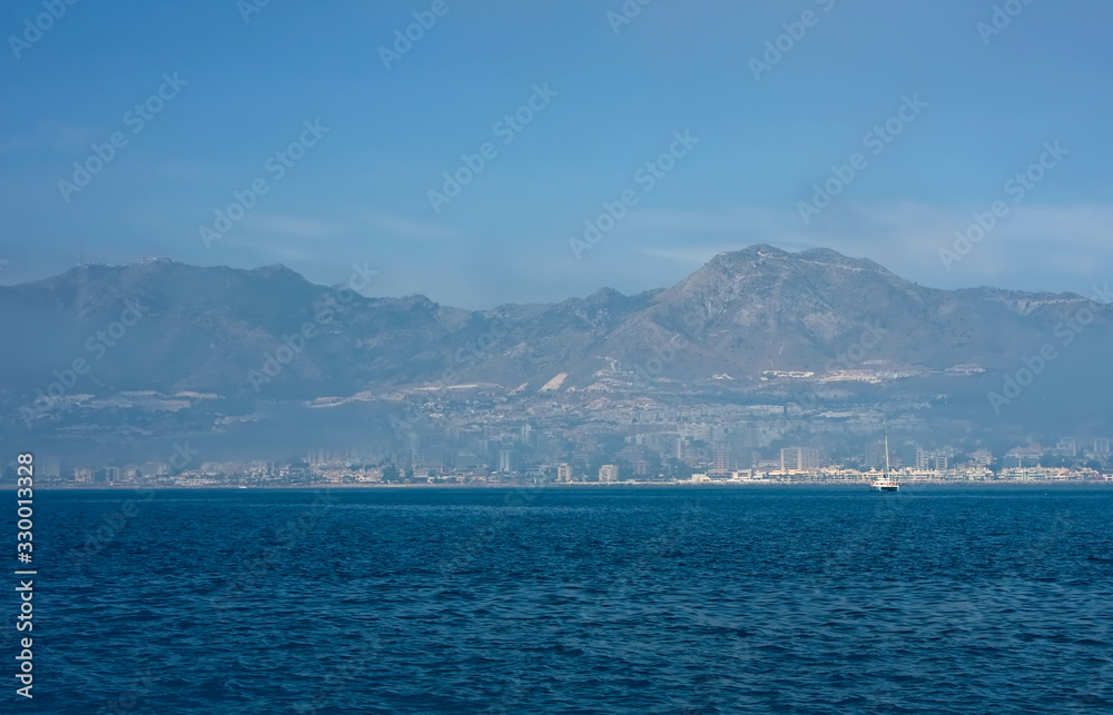Sea panorama of the city, fog and mountains