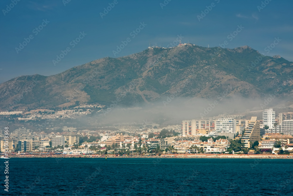 View from the sea to the city in the fog and high mountains