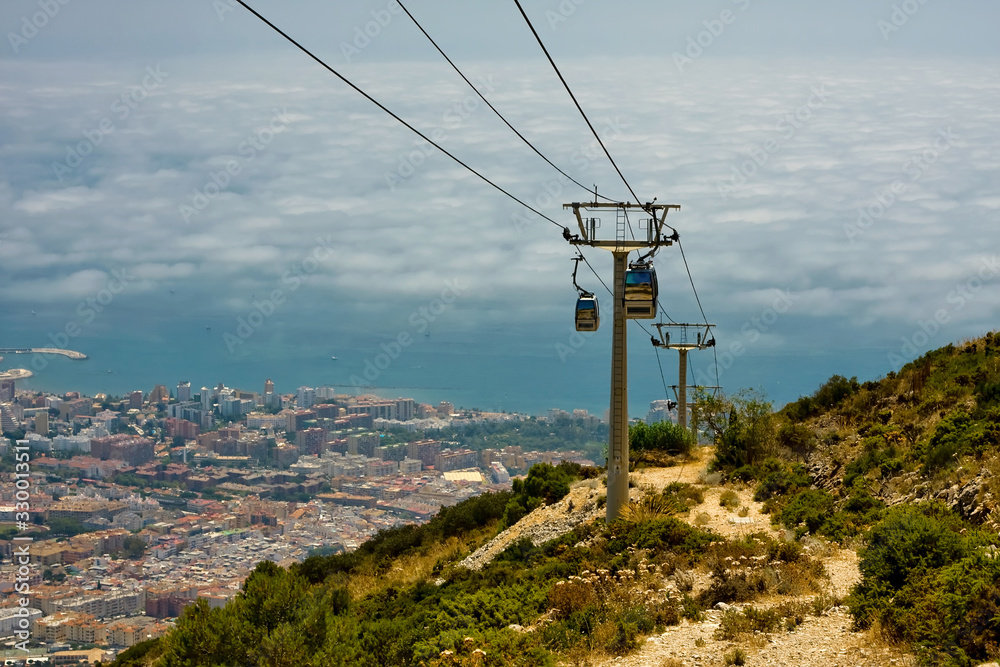 Cableway, poles, mountains, city at the foot