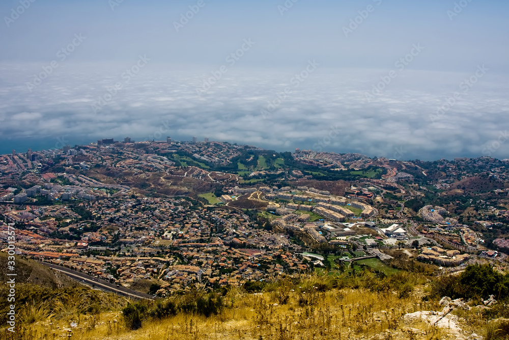 View of the city at the foot of the mountains and the sea in the fog