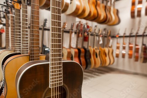 Close up of modern, wood guitar, view to instrument shop, music instrumental concept