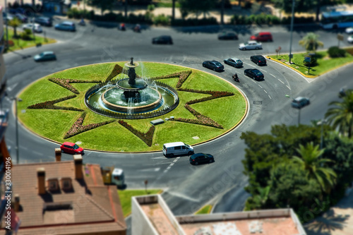 Fountain with grass and circular motion of cars