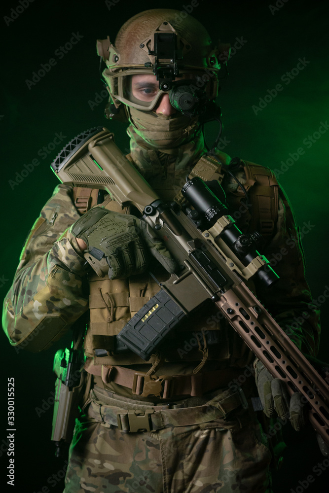 a soldier in military clothing with a night vision device and on a dark background a soldier in military clothing with a night vision device and on a dark background