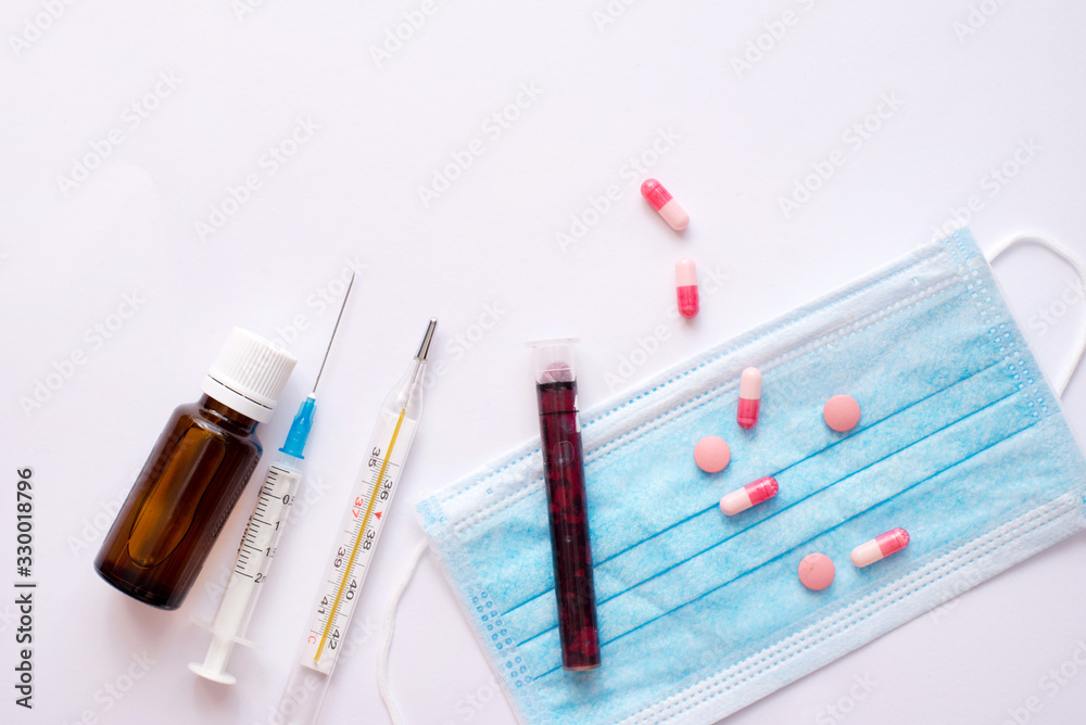 Test blood Coronavirus with tablets and protective mask on white table Test blood Coronavirus with tablets and protective mask on white table