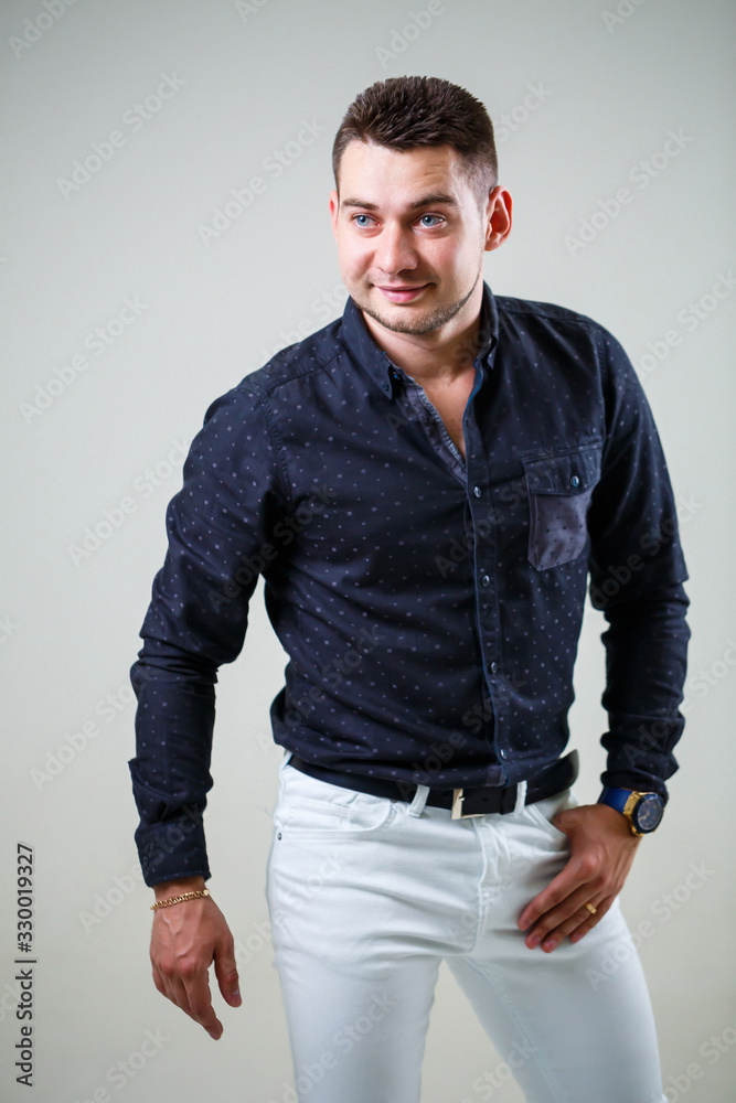 Young businessman guy in black shirt and white trousers on a white background Young businessman guy in black shirt and white trousers on a white background