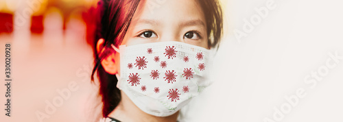 Covid-19 and Air pollution pm2.5 concept.Little chinese girl wearing mask for protect pm2.5 and virus cell on mask for protection Covid 19 outbreak.Wuhan coronavirus and epidemic virus symptoms.