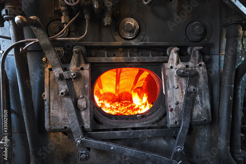 Canvas Print A steam engine train boiler with a burning fire