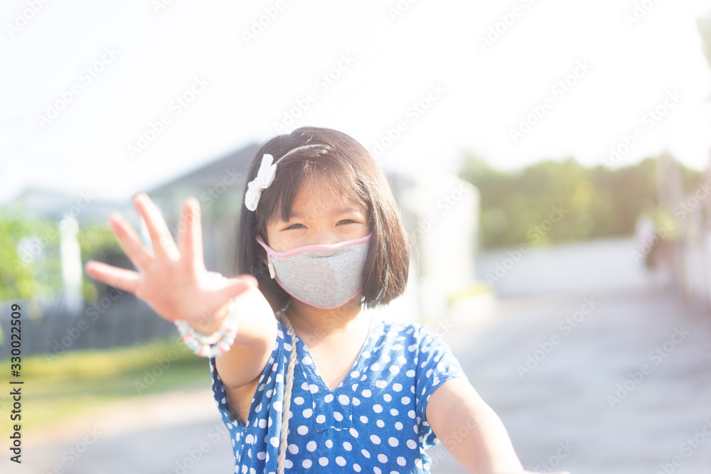6 years old happy Little asian girl child ride bicycle in the park at home and wearing protection mask for protect pm2.5 and Coronavirus Covid-19 Pandemic virus symptoms.Sport exercise for health.