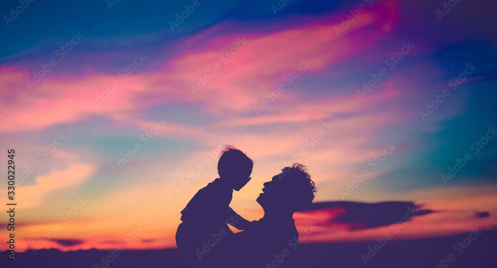 Bonding time!.Silhouette Father and his toddler son are playing and holding at sunset cloud beach.Cute little asian baby boy play with his dad.Family holiday and togetherness with beautiful scenery.
