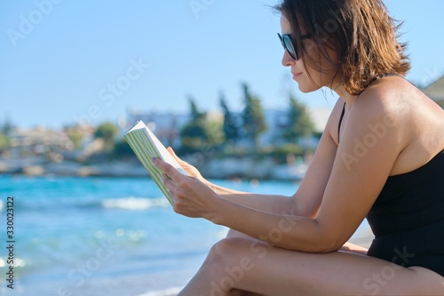 Beautiful woman 40 years old relaxing on sandy beach