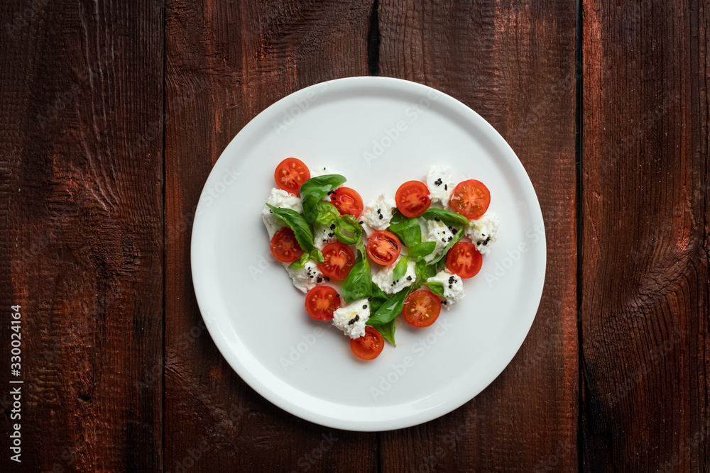 Ingredients for Caprese salad in the form of a heart. Symbol of love for Italian food Ingredients for Caprese salad in the form of a heart. Symbol of love for Italian food