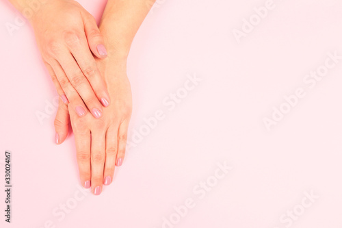 female  manicure. Beautiful young woman s hands on pastel pink  background - Image