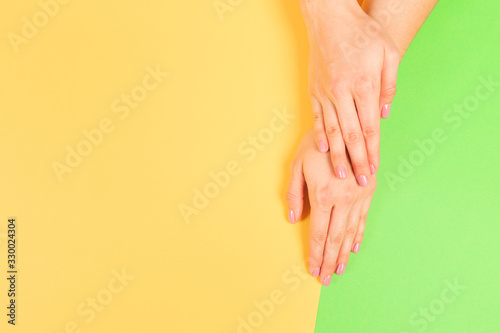 female manicure. Beautiful young woman's hands on pastel color background - Image