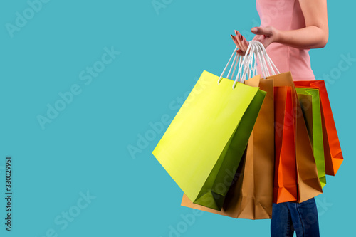 Shopping bag concept on the woman hand on the green pastel background